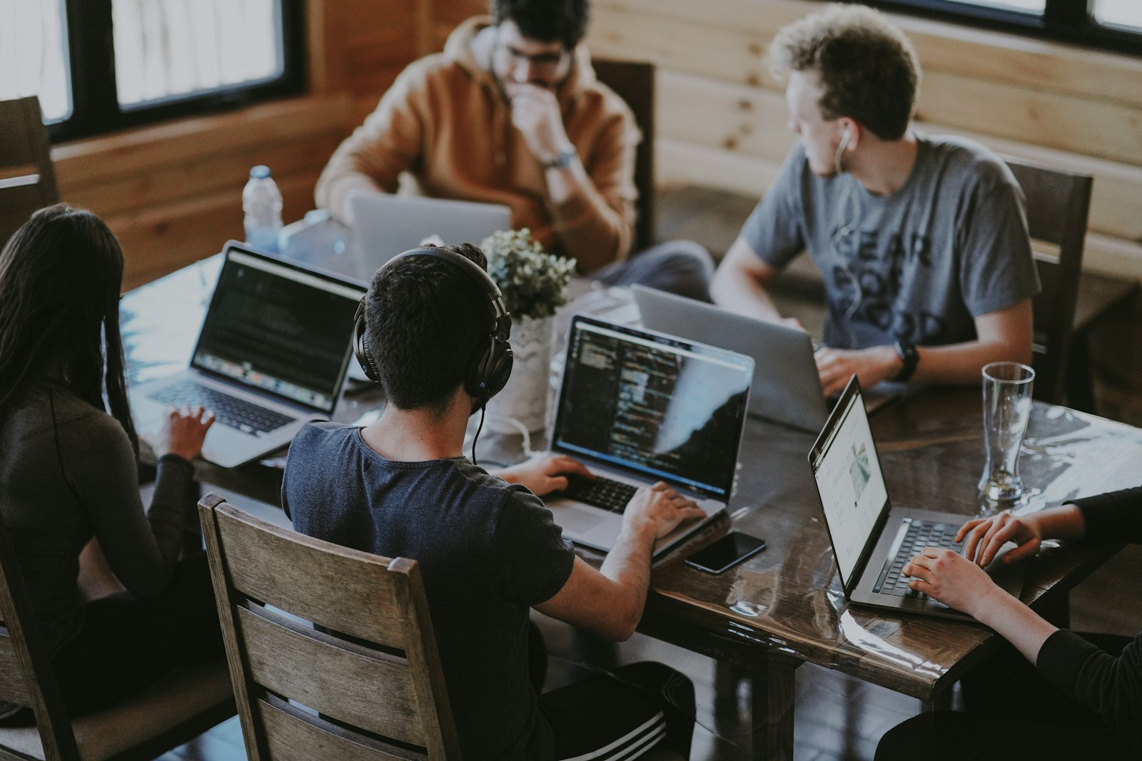 Small business team collaborating around laptops in a bright meeting space
